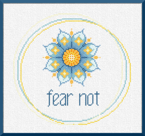 Stitching is cheaper than therapy! Fear Not product image. A mandala-style lotus in bright blues and warm yellows sits off-center amid a border of 3 loosely overlapping circles in the same colors. The legend "Fear Not" is below the lotus in blue letters. From Grimalkin Crossing .
