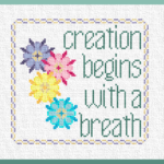 Why cross stitch? This is a prodcuct image for "With a Breath." It features four brightly colored flowers and the words "Creation Begins with a Breath" inside a purple and golden yellow border.