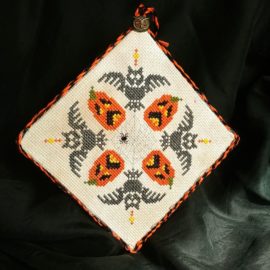 Halloween cross stitch sale! This is a photo of the finished cross stitch design "Owl Hallow's Fright Night" with spooky owls and howling jack-o-lanterns. From Grimalkin Crossing.
