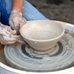 handmade decor. A clay bowl is being shaped on a potter's wheel. From Grimalkin Crossing.